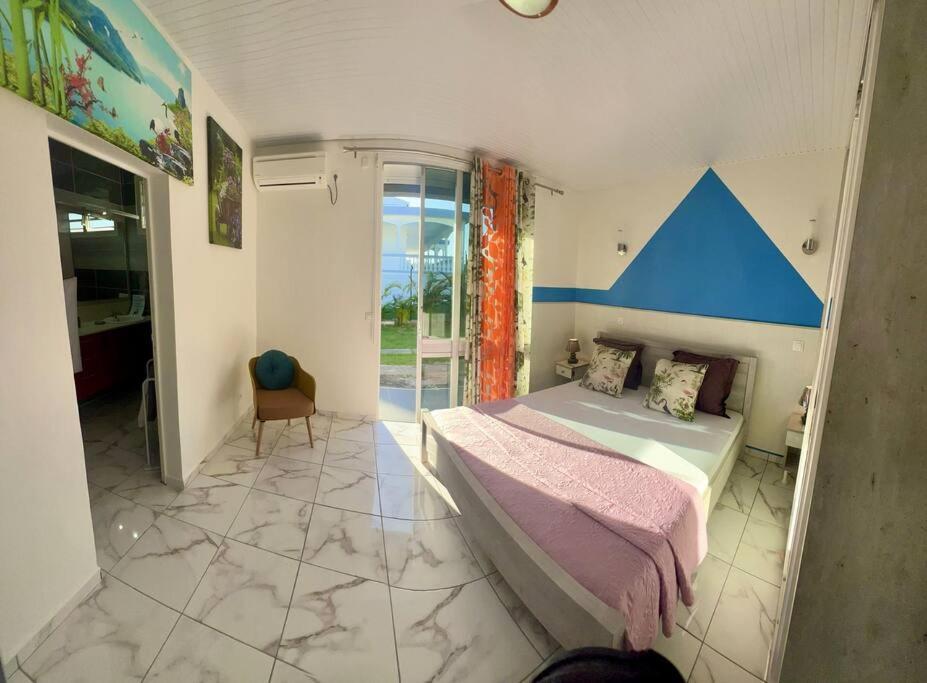 - une chambre avec un grand lit aux accents bleus dans l'établissement Villa La roche, à Le Moule