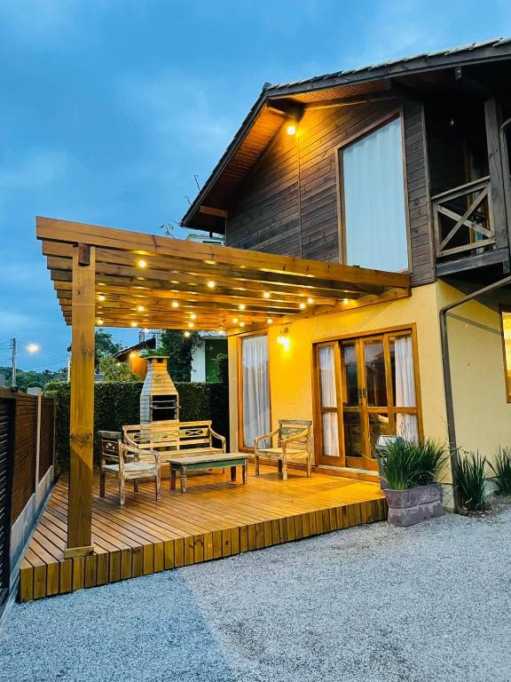 a wooden deck with a bench on a house at Morada Guarda Explorer 01 in Guarda do Embaú
