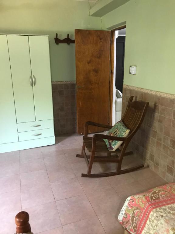 Finca Victoria في لا باندا: غرفة بها كرسي وخزانة