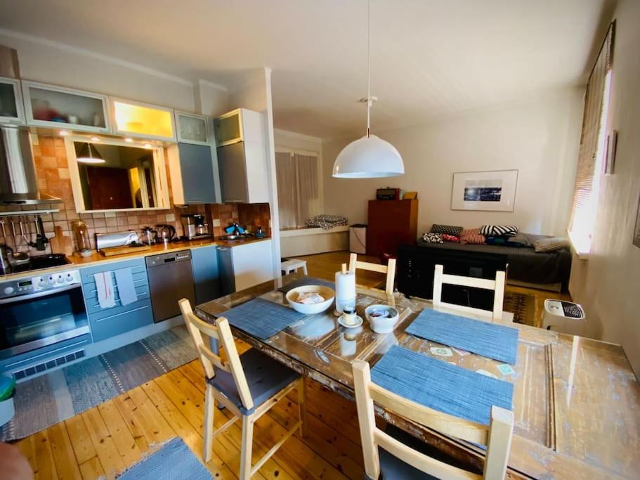 a kitchen and dining room with a table and chairs at Studio apartment, view over the roofs for the sunrise in Helsinki