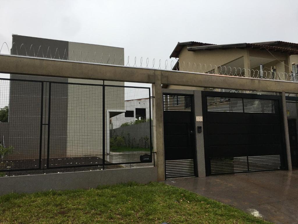 um edifício com duas portas de garagem e uma cerca em Loft próximo a UFMS em Campo Grande