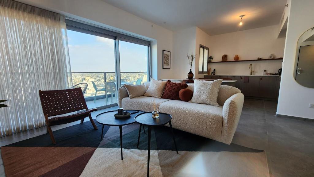 Ace By HolyGuest في تل أبيب: غرفة معيشة مع أريكة ونافذة كبيرة