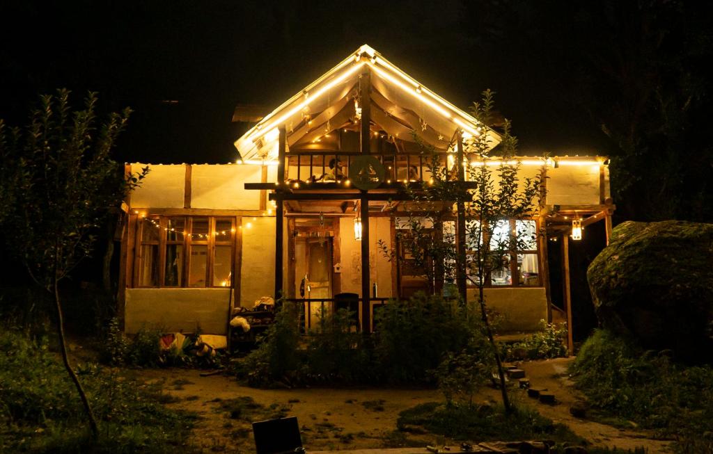 a house lit up at night with lights at Zevibes Cafe & Homestay in Kalgha