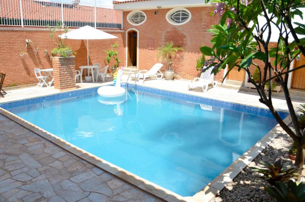 einen Pool mit blauem Wasser im Hinterhof in der Unterkunft Pousada Hospede Olimpia in Olímpia