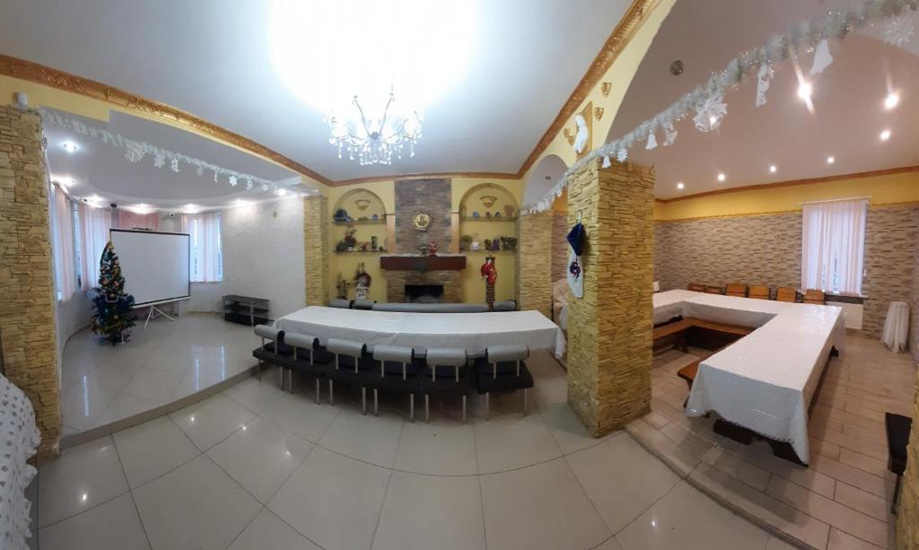 a large room with a meeting room with tables and chairs at Куренiвський Двiр in Kyiv