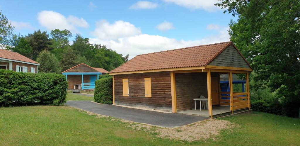 eine kleine Holzhütte mit einem Tisch im Hof in der Unterkunft Les Chalets de la MARGERIDE in Blavignac