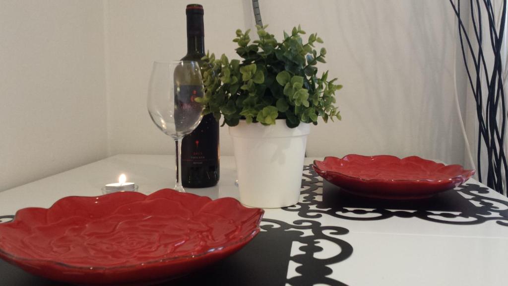 フィレンツェにあるMagico Risveglio Piazza Signoriaのテーブル(赤いボウル2本、ワイン1本、キャンドル付)