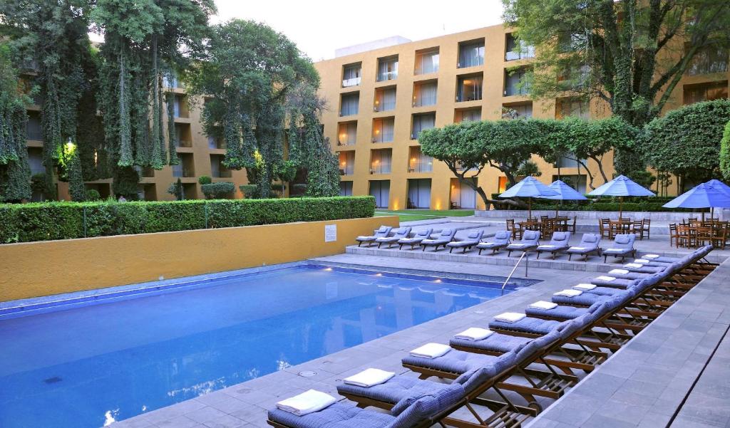 a swimming pool with lounge chairs and a hotel at Camino Real Polanco Mexico in Mexico City