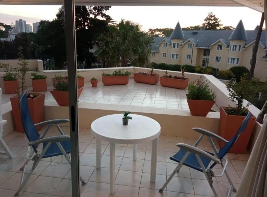 patio con mesa y sillas en el balcón en Torre Amadeus 203, en Punta del Este