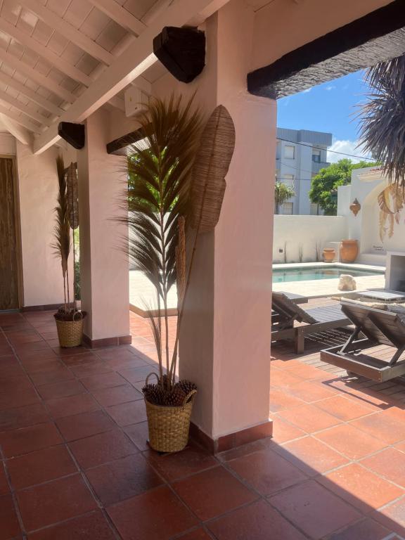 una casa con una palmera en un patio en LA CURVA Casa de Playa en Villa Gesell