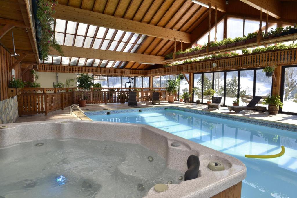 une grande piscine avec une grande baignoire dans l'établissement Hotel Le Ferraillon, à Abondance