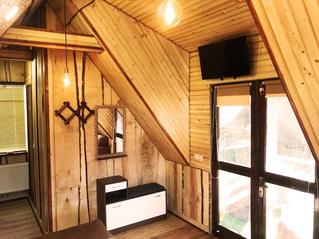 Zimmer mit Holzwänden und einem TV an der Wand in der Unterkunft Lavanda cottage in Werchowyna