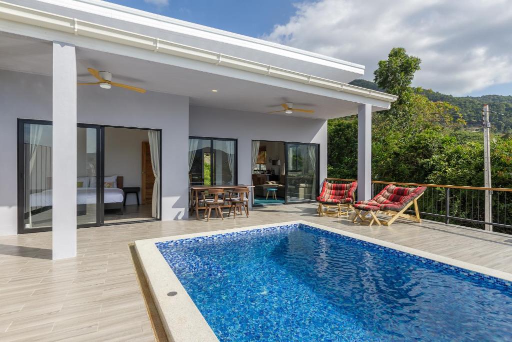 a villa with a swimming pool and a house at Villa primor Chaloklum Koh phangan in Chaloklum