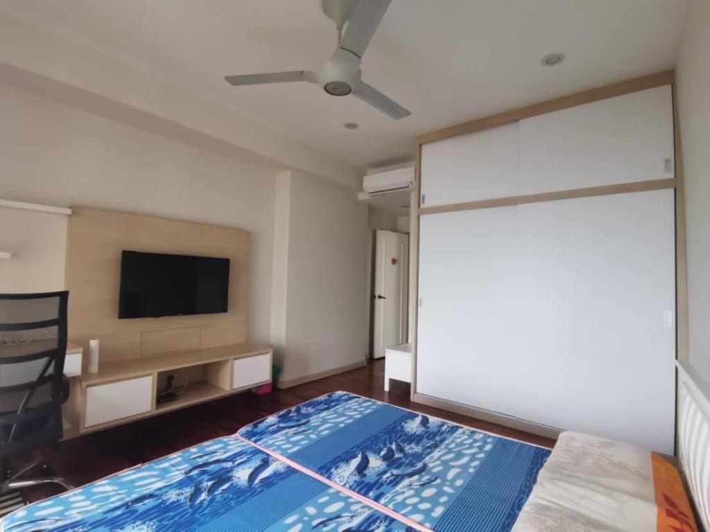 a bedroom with a bed and a flat screen tv at Ocean Palms in Melaka