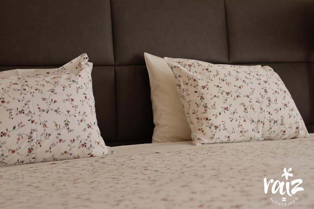 un letto con due cuscini e un copriletto con fiori di Raiz Alentejana II a Reguengos de Monsaraz