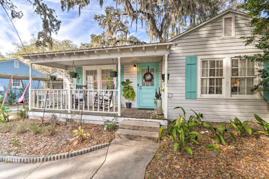 a small white house with a blue door at ~ 12 Mi to Disney: Downtown Winter Garden Cottage! in Orlando