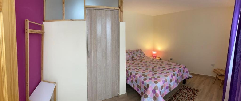 Schlafzimmer mit einem Bett und lila Wänden in der Unterkunft Katalina's Guest House Arequipa in Arequipa