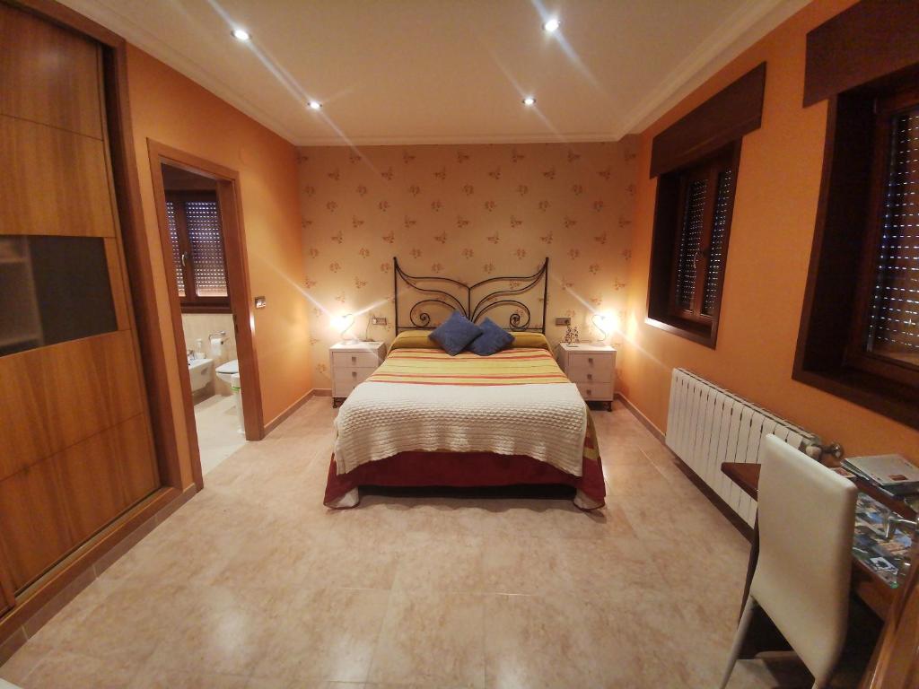 ein Schlafzimmer mit einem Bett in einem Zimmer mit orangefarbenen Wänden in der Unterkunft Casa Aida in Foz
