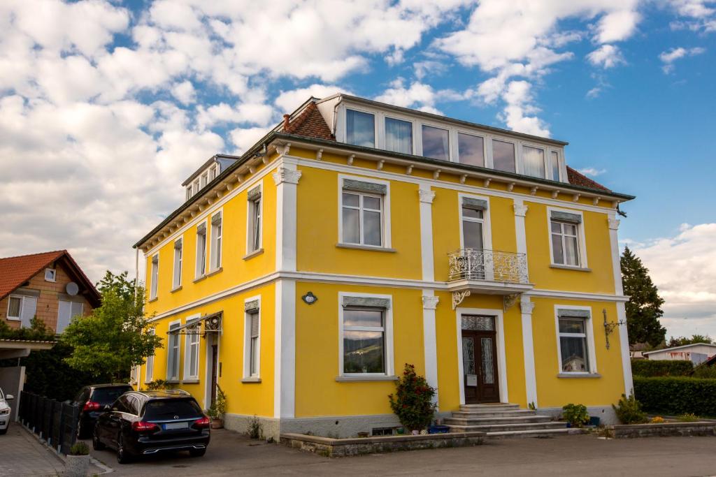 a yellow house with a car parked in front of it at Apartment Yellow in Sigmarszell