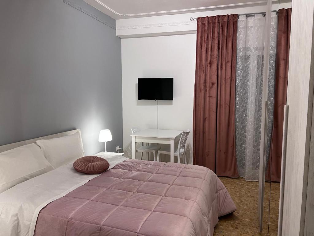 um quarto com uma cama e uma secretária com uma televisão em Residenze Unità d'Italia em Bari