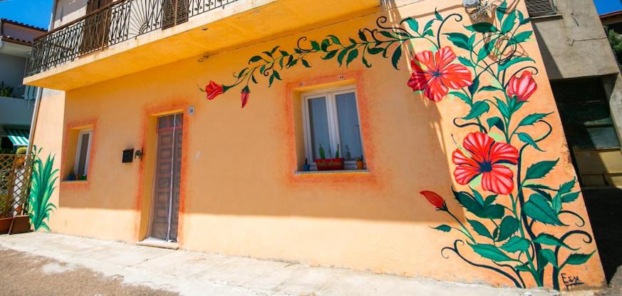 un edificio con un dipinto di fiori sul lato di Tiricca Holiday Home a Badesi