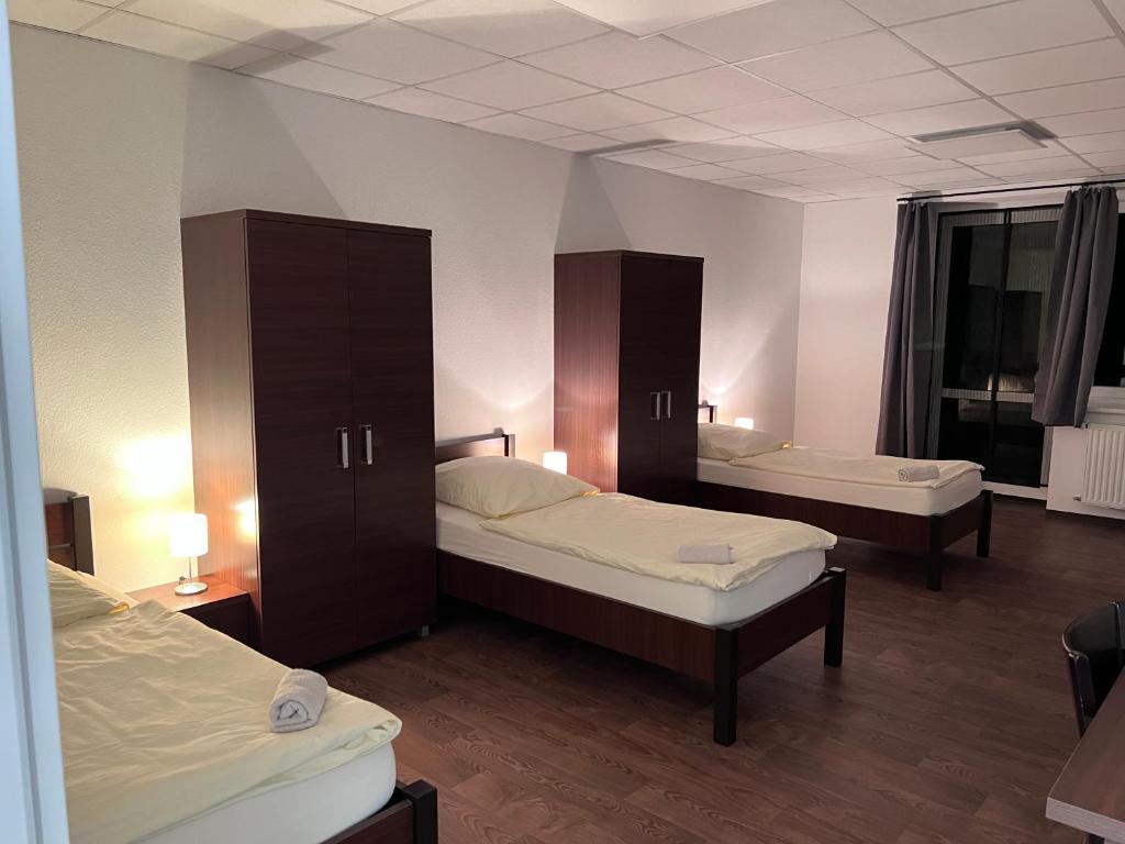 een kamer met twee bedden en kasten erin bij Apartmenthaus in Lingen