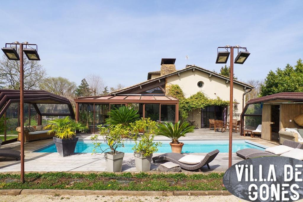 a villa with a swimming pool and a house at Villa des gones in Dommartin