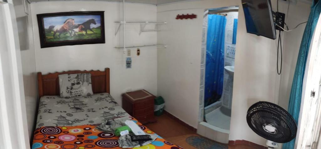 een kleine slaapkamer met een bed en een douche bij HOTEL NUEVO GALEX in Acacías