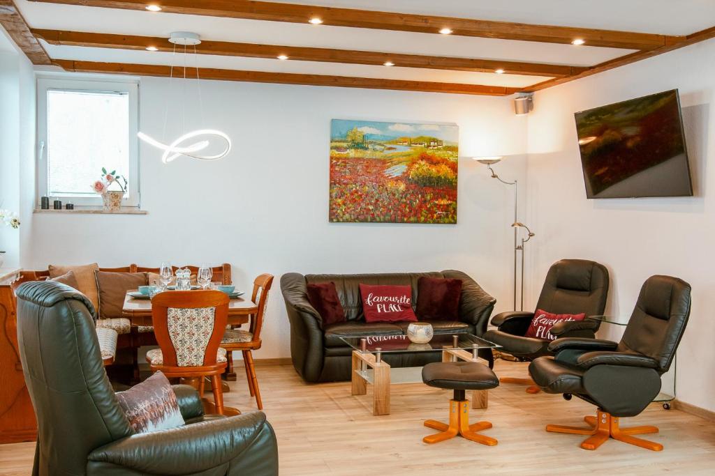 ein Wohnzimmer mit Ledermöbeln und einem Wandgemälde in der Unterkunft Ferienwohnung Bergidylle in Sankt Andreasberg