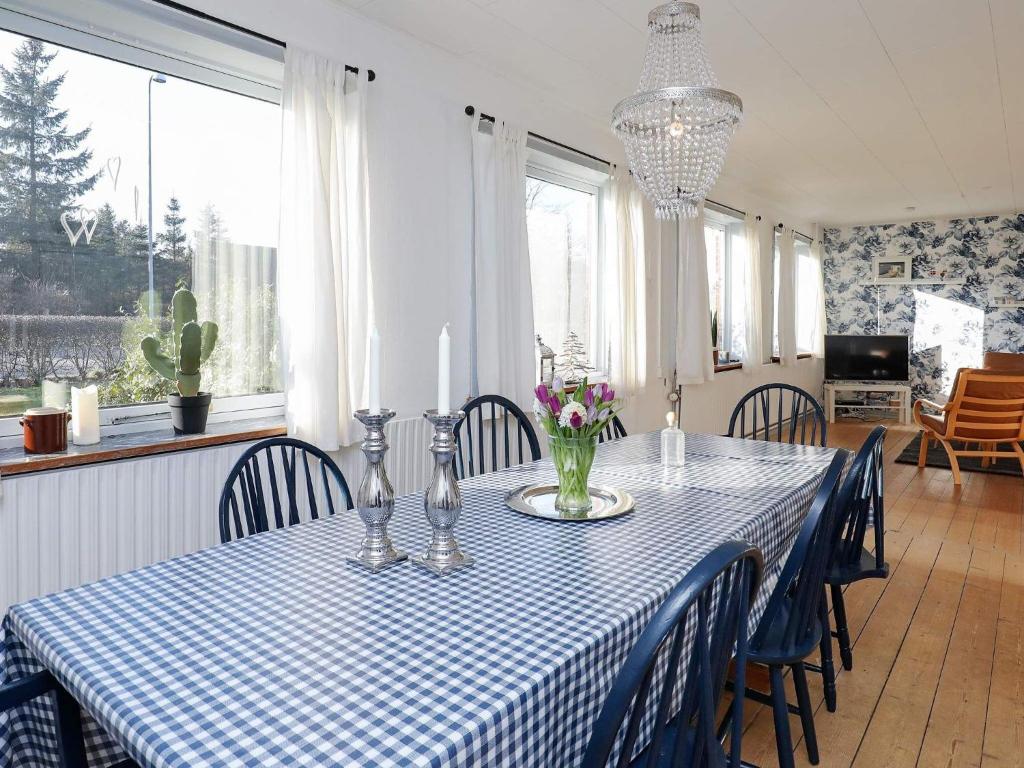 un comedor con una mesa y sillas de color azul y blanco a cuadros en Holiday home Bindslev VI, en Bindslev