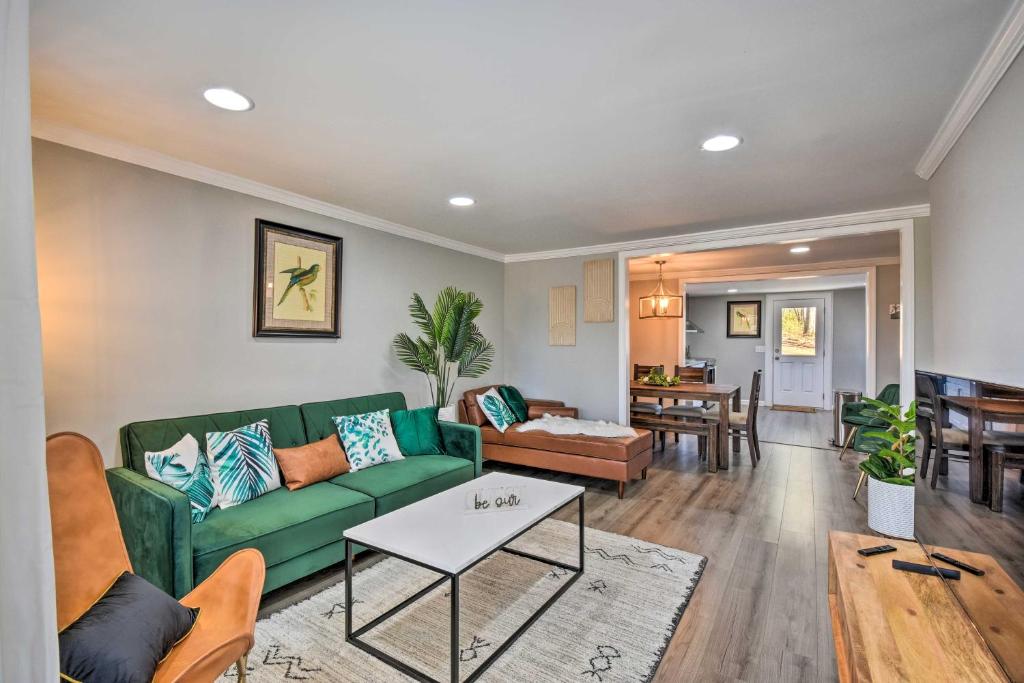a living room with a green couch and a table at Modern Commerce House Rental with Fire Pit! in Commerce