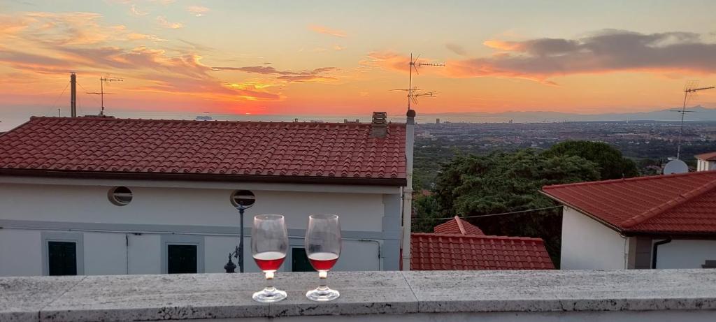 dos copas de vino sentadas en una cornisa con la puesta de sol en SEA PEARL (PERLA MARINA) en Livorno