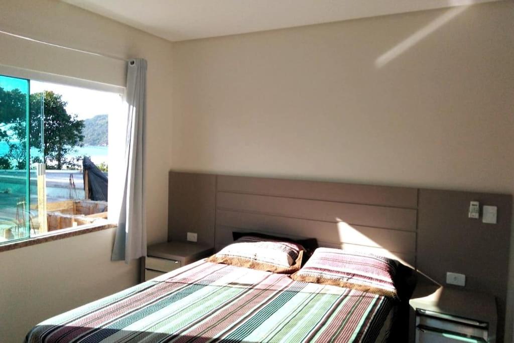 1 dormitorio con cama y ventana grande en Casa com spa- cod 113, en Bombinhas