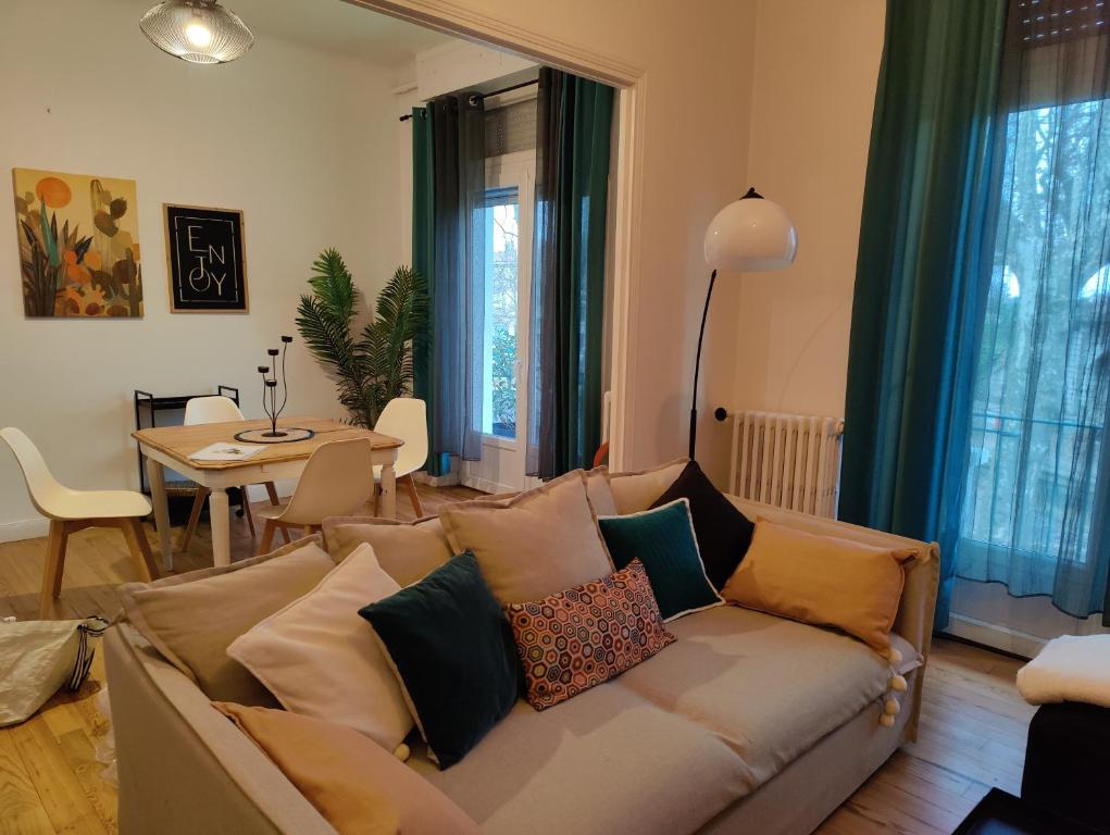sala de estar con sofá y almohadas en L'appart du Canal, en Carcassonne