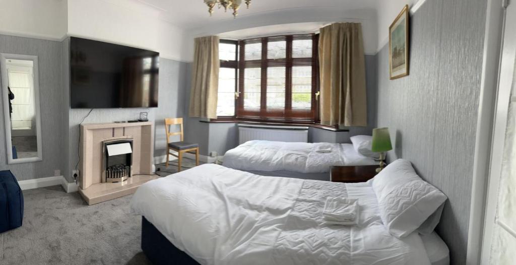 um quarto de hotel com duas camas e uma lareira em Amazing and Romantic O2 Arena 4 Bedrooms House free parking em Londres