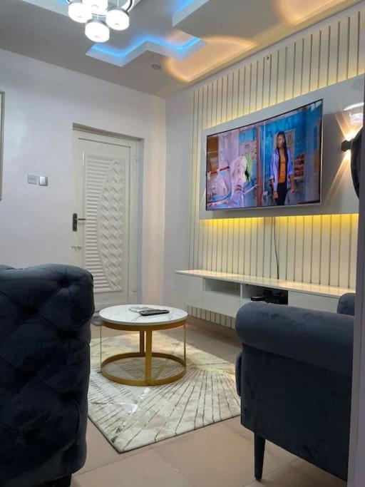 a living room with a tv and a couch and a table at GS HOMES in Lagos