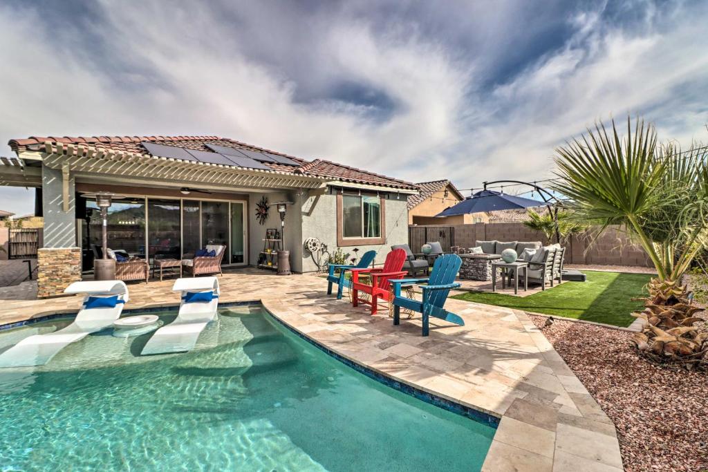 a swimming pool with chairs and a house at Stunning Goodyear Vacation Rental with Private Pool! in Goodyear