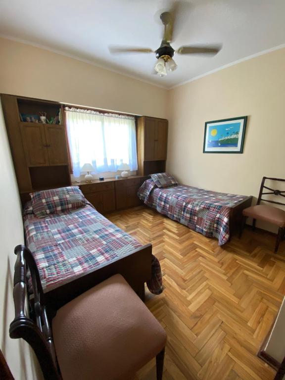 1 dormitorio con 2 camas y ventilador de techo en España Libertad en Mar del Plata