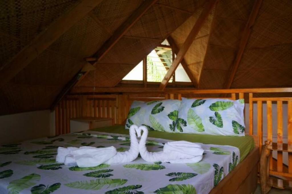 a bed with white towels on it in a room at Hotel Renate in Panglao