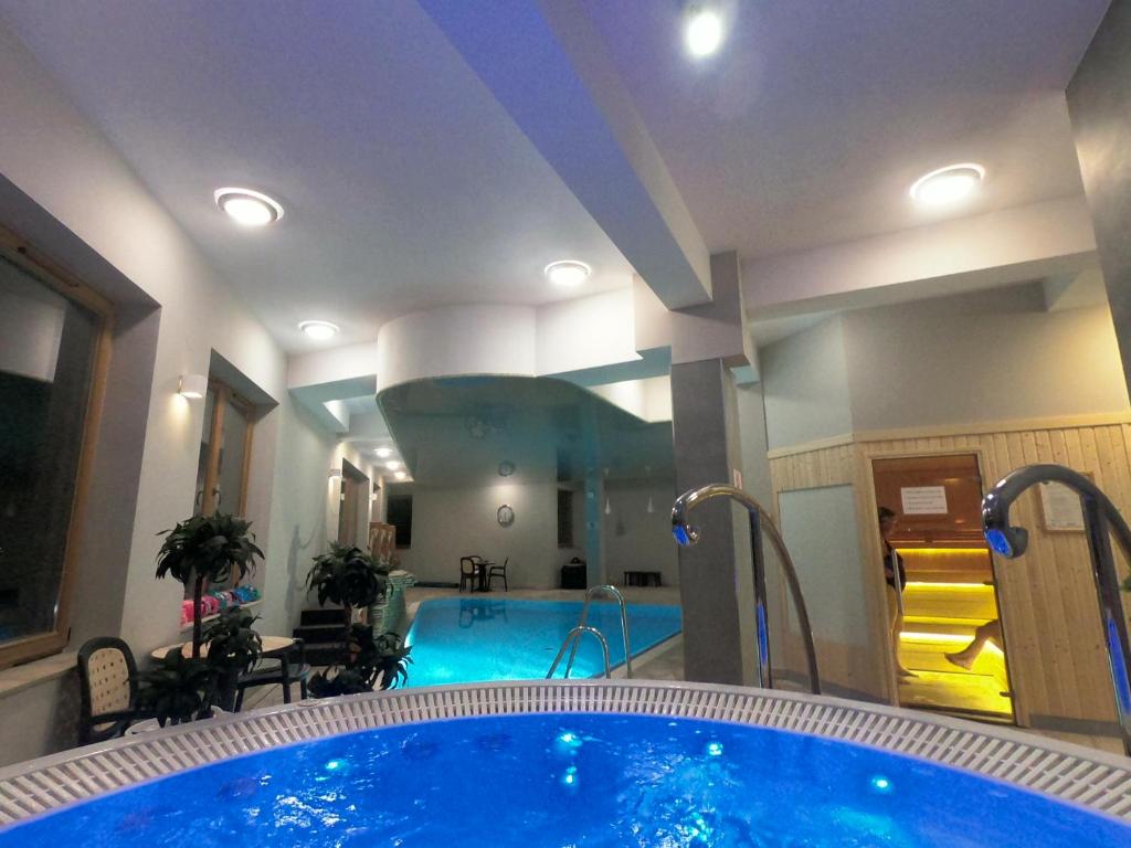 a large tub in a room with a swimming pool at Apartament Królewski Superior z sauną in Zakopane
