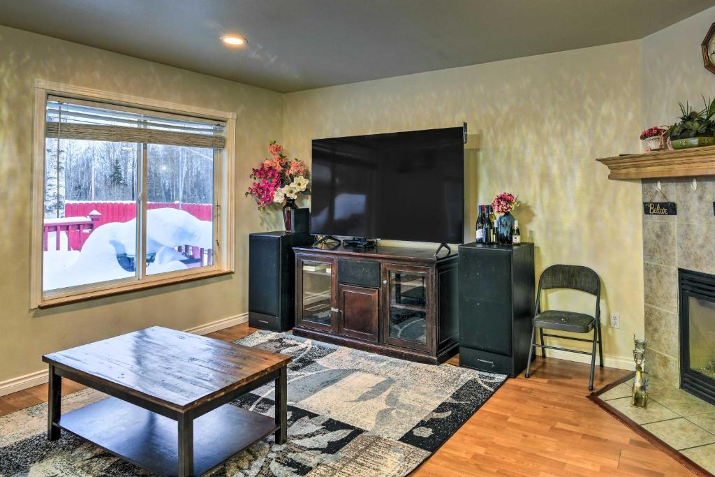 ein Wohnzimmer mit einem Flachbild-TV und einem Couchtisch in der Unterkunft Anchorage Home 4 Mi to Alaska Zoo! in Anchorage