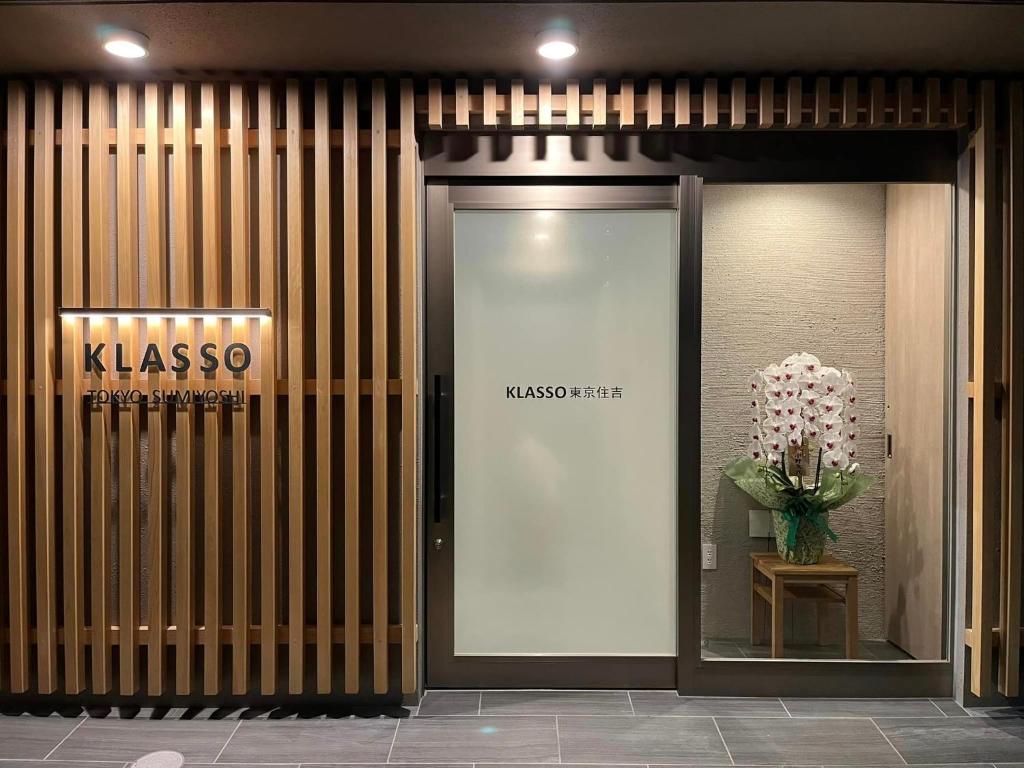 a building with a glass door with a vase of flowers at KLASSO Tokyo Sumiyoshi Apartments in Tokyo
