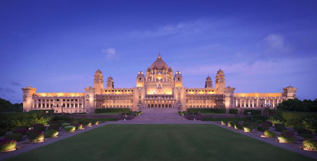 un gran edificio con césped delante en Umaid Bhawan Palace Jodhpur en Jodhpur