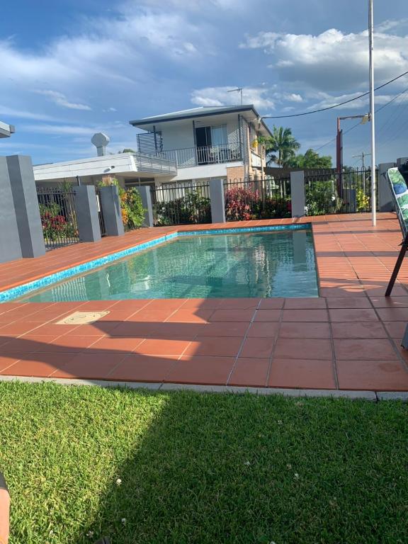 a swimming pool in front of a house at Shady Rest Motel in Gympie