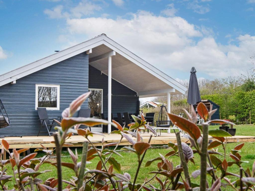 une maison bleue avec une terrasse et un parasol dans l'établissement Holiday home Sydals LXXVII, à Sønderby