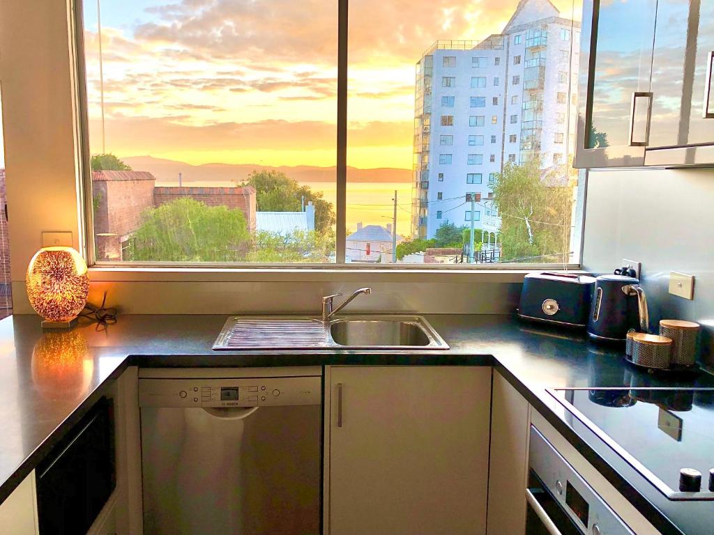 a kitchen with a sink and a large window at Scarlett's by Salamanca in Hobart