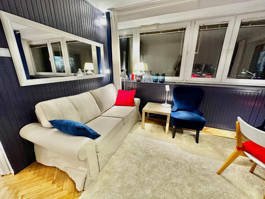 a living room with a white couch and blue chairs at SAWA 5 metro WiFi 70'TV Netflix HBO Disney+ AppleTV+ in Warsaw