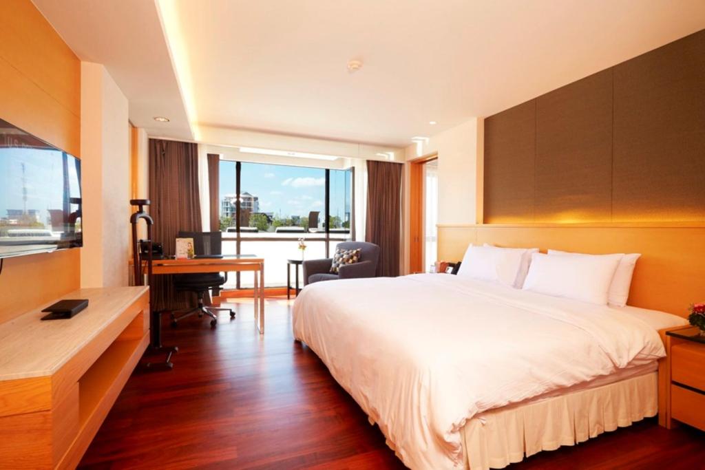 a hotel room with a large bed and a desk at Lao Plaza Hotel in Vientiane