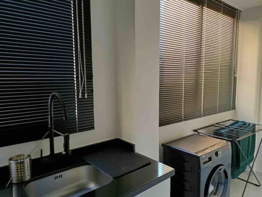 a kitchen with a sink and a washing machine at Neuf et raffiné, centre ville Rabat in Rabat