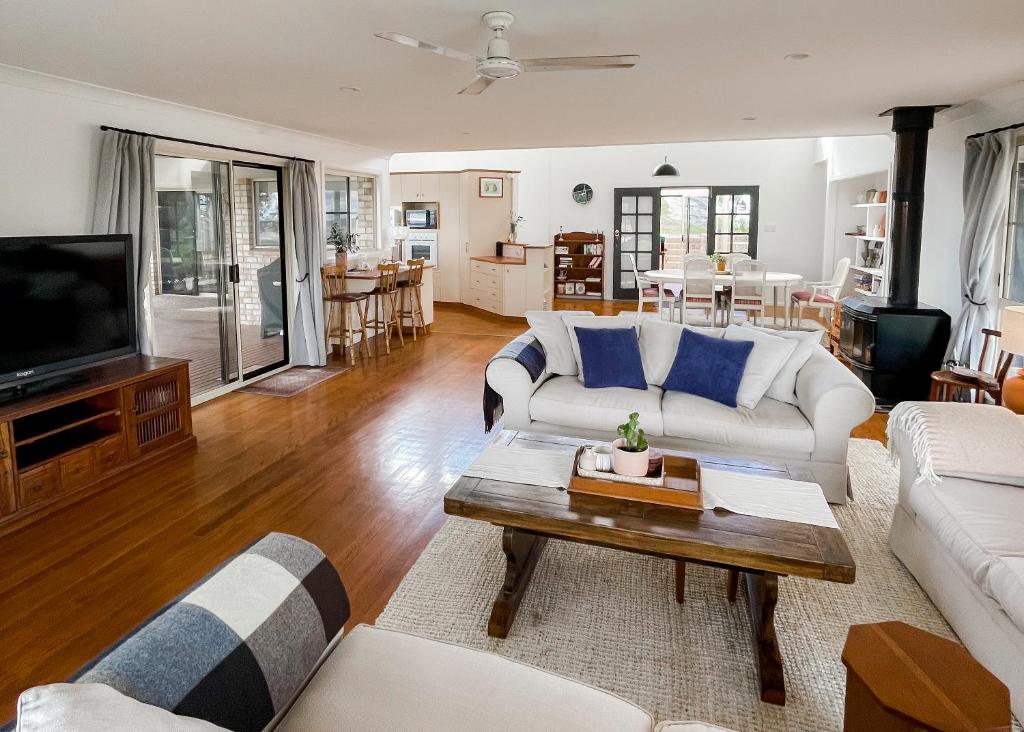 sala de estar con sofá blanco y TV en Ballandean Views, Ballandean Queensland, en Ballandean